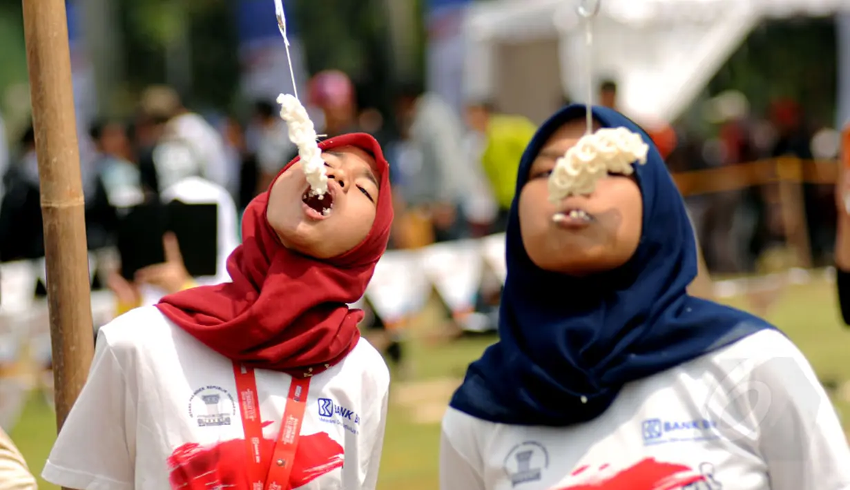 Lomba makan kerupuk memeriahkan HUT RI ke-69 di kawasan Tugu Monas, Jakarta, (31/8/2014). (Liputan6.com/Helmi Fithriansyah)