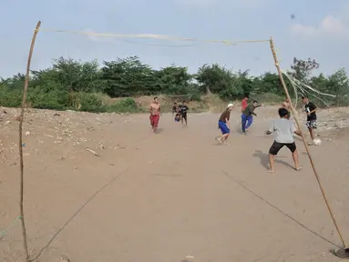 Anak-anak saat bermain sepakbola di tanah sengketa kawasan Pedongkelan, Jakarta, Kamis (11/7/2019). Meski bertempat tinggal di atas lahan sengketa, anak-anak setempat memanfaatkan tanah kosong yang penuh semak belukar tersebut sebagai sarana bermain ketika sore hari. (merdeka.com/Iqbal S. Nugroho)