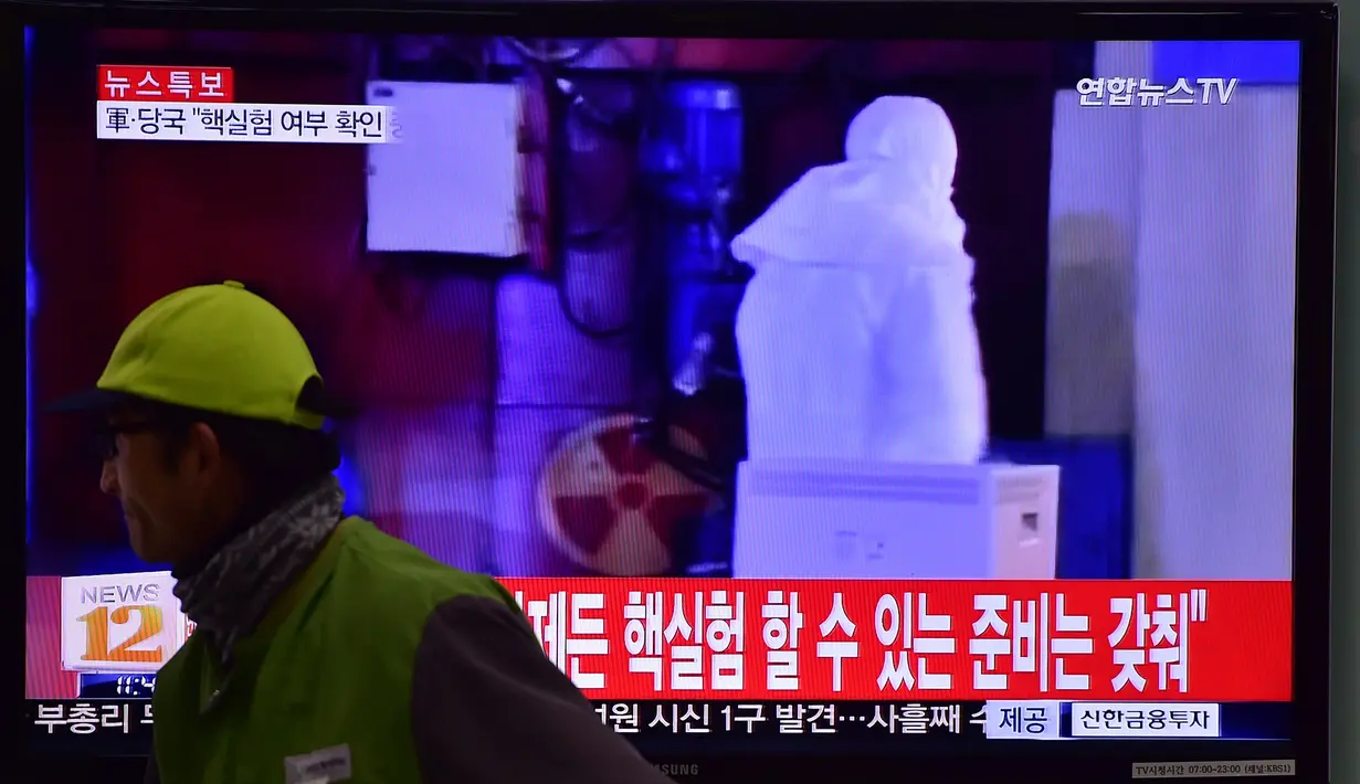 Seorang pria berjalan melewati sebuah layar TV yang menunjukkan laporan berita di sebuah stasiun kereta api di Seoul, Korea Selatan, Rabu (6/1/2016). Gempa berkekuatan 5,1 SR terdeteksi di dekat tempat uji coba nuklir Korea Utara. (AFP PHOTO/Jung Yeon-Je)