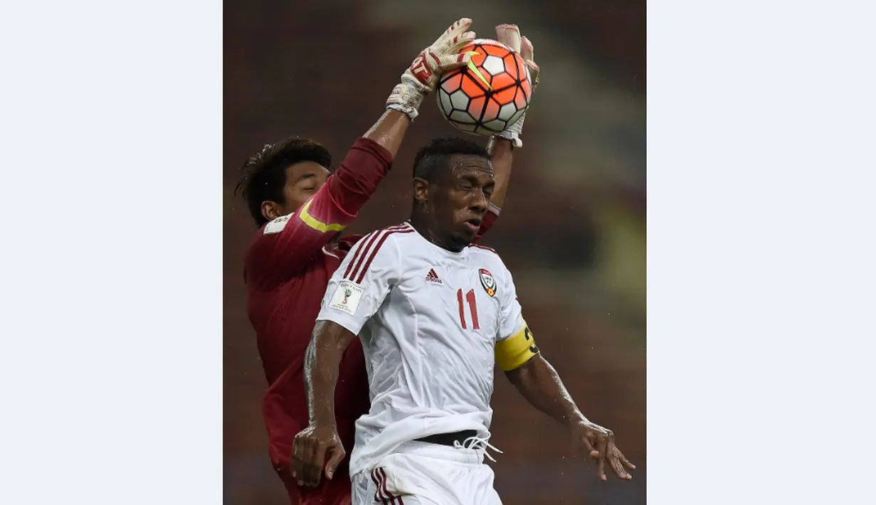 Kiper Malaysia, Mohd Izham Tarmizi (kiri), berusaha mengamankan bola dari pemain UEA, Ahmed Khalil, dalam Kualifikasi Piala Dunia 2018 di Stadion Shah Alam, Malaysia, (17/11/2015). Malaysia kalah 1-2 dari UEA. (AFP Photo/Manan Vatsyayana)