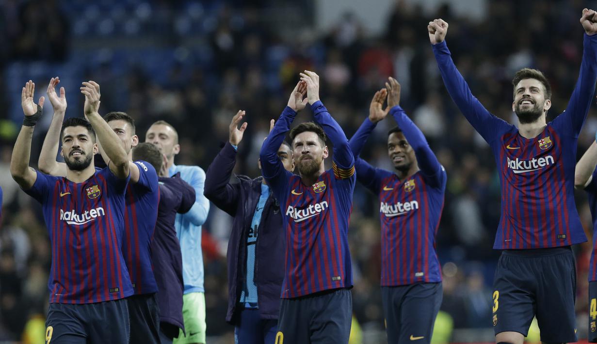 Para pemain Barcelona merayakan kemenangan atas Real Madrid pada laga La Liga di Stadion Santiago Bernabeu, Sabtu (2/3). Real Madrid takluk 0-1 dari Barcelona. (AP/Andrea Comas)