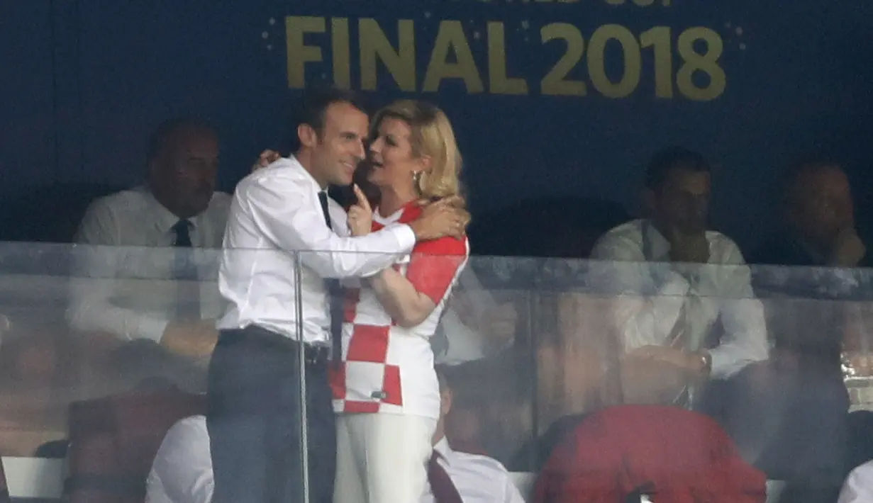 Presiden Kroasia Kolinda Grabar-Kitarovic (kanan) berbicara kepada Presiden Prancis Emmanuel Macron (kiri) selama pertandingan final Piala Dunia 2018 antara Prancis dan Kroasia di Stadion Luzhnik, Moskow, Rusia, Minggu (15/7). (AP Photo/Natacha Pisarenko)