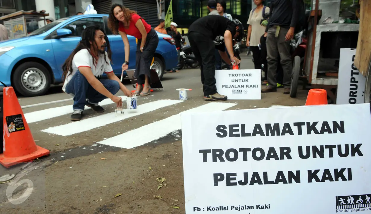 Para Aktivis Pejalan Kaki mengecat marka jalan  di kawasan Tosari, Jakarta, Jumat (11/12). Aksi tersebut di merupakan teguran untuk pemerintah agar serius menangani masalah kecelakaan. (Liputan6.com/Helmi Afandi)