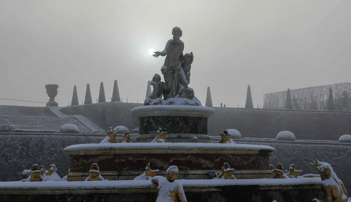 Namun, di sisi lain, cuaca ekstrem ini justru menjadi tantangan besar. Tampak dalam foto, salju menyelimuti Kolam Latona dan Parterre di taman Versailles, luar Kota Paris pada Selasa 6 Januari 2026. (GEOFFROY VAN DER HASSELT/AFP)