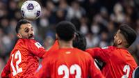 Pemain Bahrain, Mahdi Abdul Jabbar (kiri, nomor 12), menyundul bola saat berhadapan dengan tuan rumah Jepang pada lanjutan Kualifikasi Piala Dunia 2026 di Saitama Stadium, Kamis (20/3/2025) sore WIB. (Philip FONG / AFP)