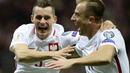 Pemain Polandia, Krzysztof Maczynski dan Kamil Grosicki, melakukan selebrasi usai cetak gol ke gawang Montenegro pada Kualifikasi Piala Dunia 2018 di Stadion National, Minggu (8/10/2017). Polandia menang 4-2 atas  Montenegro. (AP/Alik Keplicz)