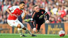 Pemain Manchester United Wayne Rooney berebut bola dengan pemain Arsenal Alexis Sanchez  pada Laga lanjutan Liga Premier Inggris di Emirates Stadium. Minggu (04/10/2015). Arsenal menang 3-0 atas MU.(Reuters / Dylan Martinez)