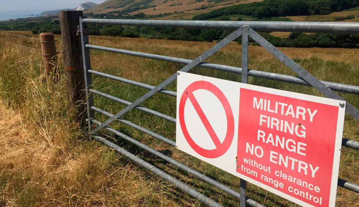 Tanda dari Menteri Pertahanan Inggris yang memperingatkan pengunjung bahwa mereka berada di jarak tembak dekat Dorset, Inggris, 8 Juli 2018. Tyneham berada di tangan militer sejak 1943 hingga saat ini. (AP Photo/Jerry Harmer)