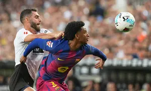 Luis Rioja dan Alejandro Balde berebut bola dalam laga Liga Spanyol antara Valencia vs Barcelona di Mestalla, 24 Mei 2026. (AP Photo/Alberto Saiz)