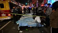 Jenazah para korban, yang diyakini menderita serangan jantung, ditutupi di distrik kehidupan malam populer Itaewon di Seoul, Korea Selatan, Minggu (30/10/2022). Data terbaru yang dirilis pihak berwenang menyebut setidaknya 146 orang telah tewas dan 150 orang lainnya terluka dalam tragedi Halloween Itaewon. (Photo by JUNG YEON-JE / AFP)