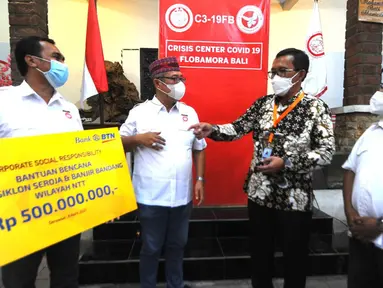 Direktur Utama PT Bank Tabungan Negara (Persero) Tbk. Haru Koesmahargyo (kedua kanan) menyerahkan secara simbolis bantuan CSR senilai Rp500 juta kepada Ketua Ikatan Keluarga Besar (IKB) masyarakat NTT-Flobamora yang berada di Denpasar, Bali, Jumat (09/04/2021). (Liputan6.com/Pool/BTN)