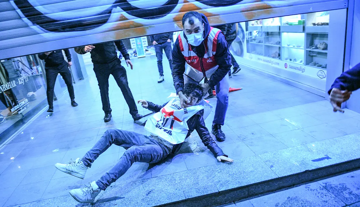 Polisi menahan seorang pria saat berdemonstrasi menentang krisis ekonomi dan biaya hidup yang tinggi di Istanbul, Tuki, 24 November 2021. Mata uang Turki, Lira, jatuh ke rekor terendah terhadap dolar dengan nilai mencapai USD 13.44 per 1 Lira. (Bulent Kilic/AFP)