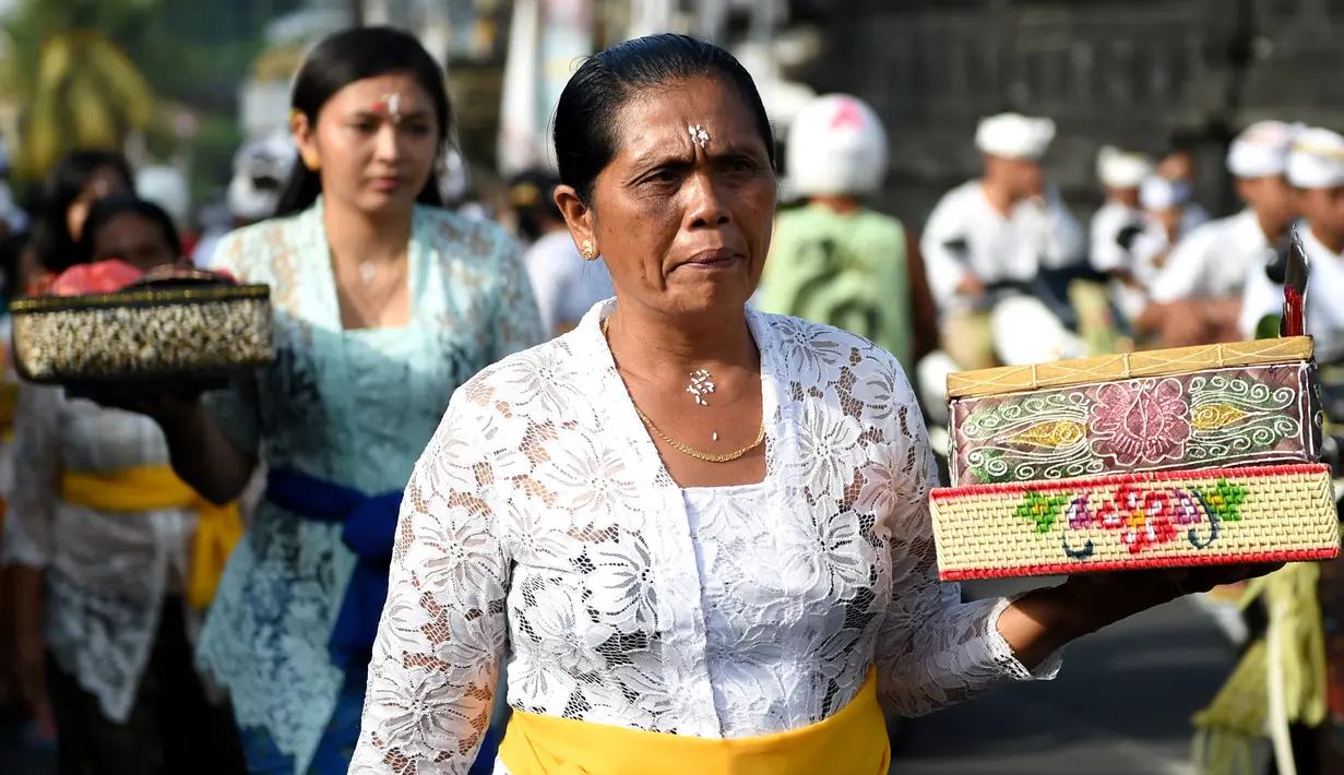 Seorang wanita Hindu membawa sesajen menuju pura untuk sembahyang Hari Raya Galungan di Jimbaran, Bali, Rabu (5/4). Galungan dirayakan oleh umat hindu di Bali sebagai hari kemenangan Dharma (Kebaikan) melawan Adharma (Keburukan). (SONNY TUMBELAKA/AFP)