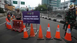 Petugas melakukan penjagaan di kawasan yang ditutup saat penyekatan di ruas jalan Mampang Prapatan, Jakarta, Kamis (15/7/2021). Mampang menjadi salah satu jalan yang masuk dalam penyekatan baru pada Pemberlakuan Pembatasan Kegiatan Masyarakat (PPKM) darurat di Ibu Kota. (merdeka.com/Imam Buhori)