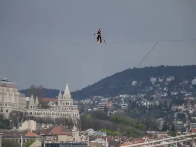 Seniman sirkus berusia 63 tahun Laszlo Simet berjalan di atas tali melintasi dua tepi sungai Danube di pusat kota Budapest pada Sabtu, 15 April 2023. (AP Photo/Denes Erdos)
