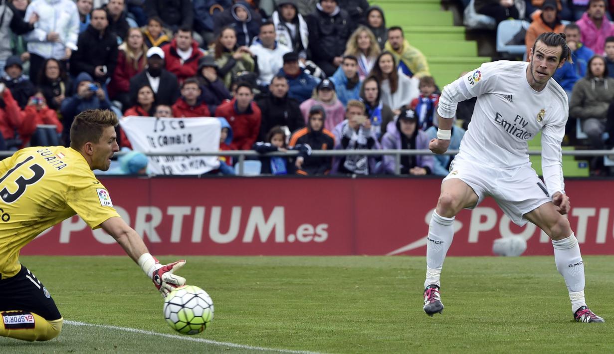 Gareth Bale saat mengecoh kiper Getafe Vicente Guaita pada lanjutan La Liga Spanyol di Stadion Colisseum Alfonso Perez, Getafe, Sabtu (16/4/2016) malam WIB. (AFP/Gerard Julien)