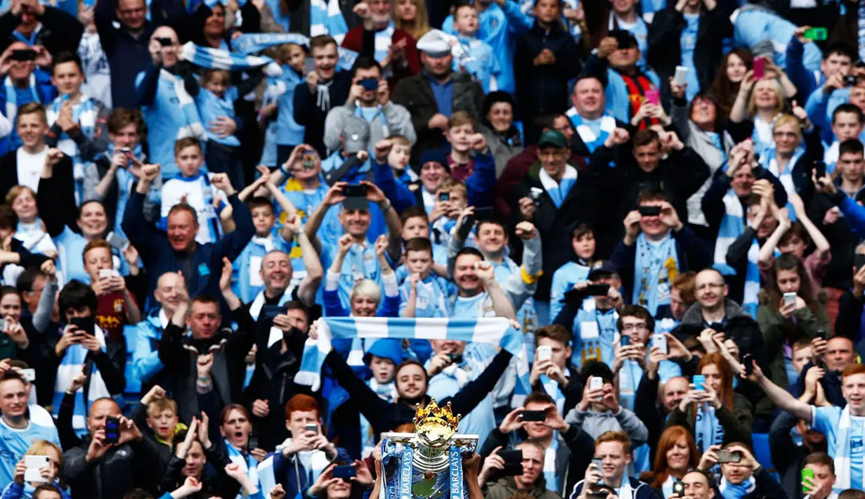 Para pemain Manchester City memamerkan trofi Liga Primer Inggris ke arah para suporter yang memadati Stadion Etihad, Manchester (11/5/2014). (REUTERS/Darren Staples)