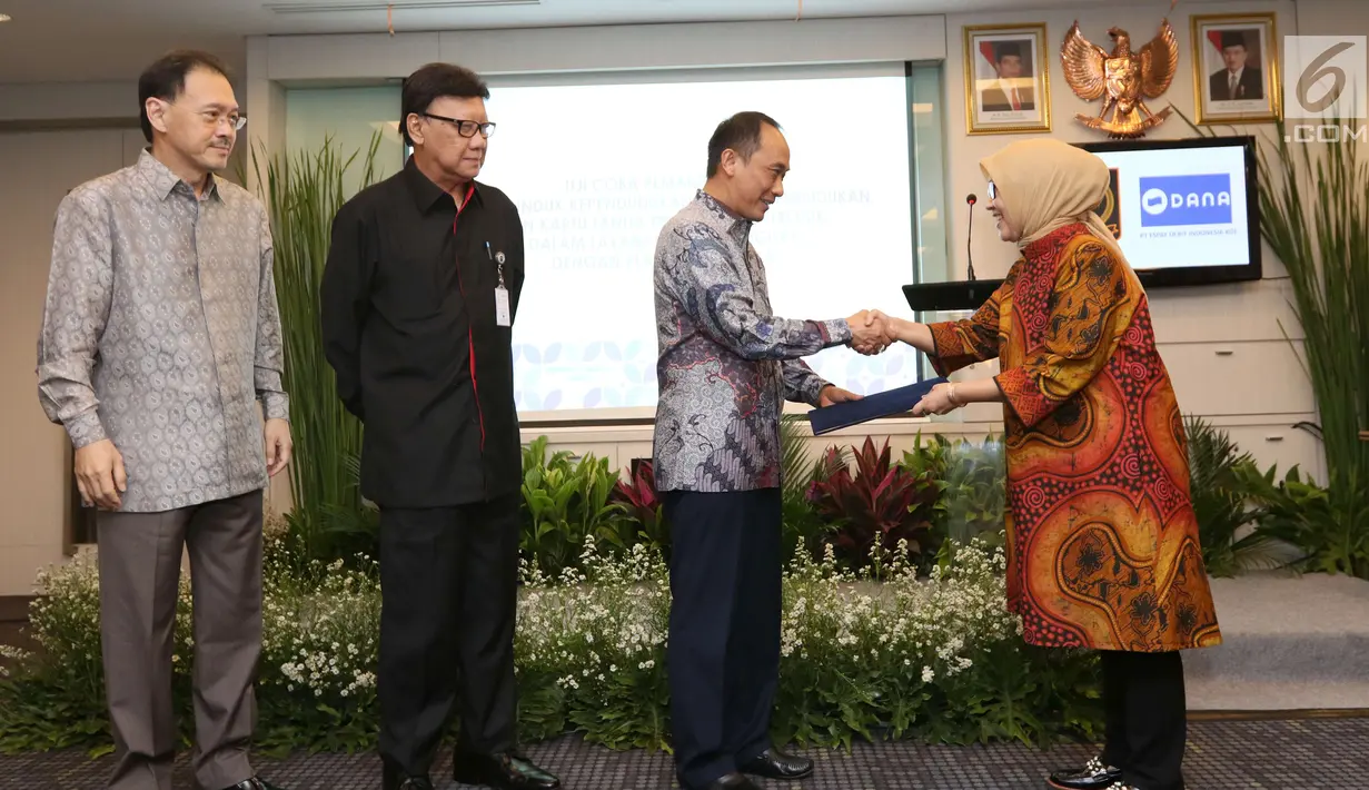 Dirjen Dukcapil, Zudan Arif Fakrulloh (kedua kanan) disaksikan Komisaris Utama PT Emtek Eddy Sariaatmadja, Mendagri Tjahyo Kumolo bersalaman dengan Direktur PT. Emtek Yuslinda Nasution (kanan) di Jakarta, Jumat (13/7). (Liputan6.com/Angga Yuniar)
