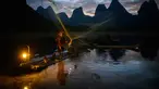 Foto yang diambil pada 25 Oktober 2025 ini menunjukkan seorang nelayan sedang memamerkan teknik tradisional memancing dengan burung kormoran kepada wisatawan di luar Yangshuo, Provinsi Guangxi, Tiongkok. (Mladen ANTONOV/AFP)