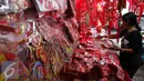 Seorang penjual pernak-pernik Imlek sedang menata dagangannya di Glodok, Jakarta, Rabu (18/01). Warna merah yang mendominasi pernak-pernik sudah menghiasi diberbagai sudut di Pasar Glodok yang mewakili suasana imlek tahun ini. (Liputan6.com/JohanTallo)
