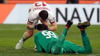 Pemain AC Milan Alessio Romagnoli mengucapkan selamat kepada Gianluigi Donnarumma usai menang atas Lazio pada laga leg kedua semifinal Coppa Italia di Stadio Olimpico, Rabu (28/2). Milan lolos ke final lewat adu penalti 5-4. (Ettore Ferrari/ANSA via AP)