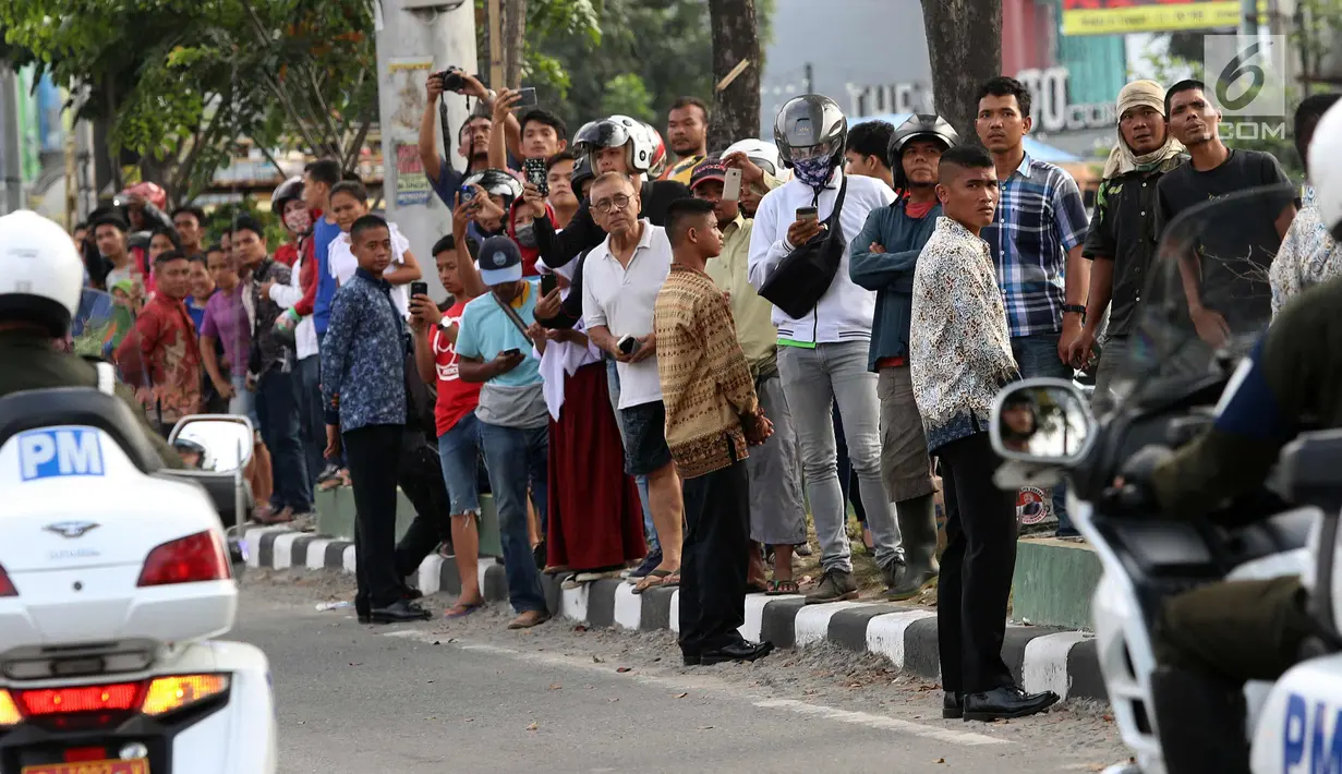 Warga mengabadikan momen simulasi kirab pernikahan Kahiyang Ayu dan Bobby Nasution, Medan, Rabu (22/11). Simulasi dimulai dari Medan International Convention Center, Jl Gagak menuju kediaman Bobby di Bukit Hijau Regency (BHR). (Liputan6.com/Johan Tallo)