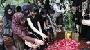 Penaburan bunga di atas makam Yana Zein di TPU Gandul, Cinere, Depok, Jumat (2/6). Yana Zein meninggal pada kamis (1/6/2017), karena kanker payudara stadium VI yang dideritanya. (Liputan6.com/Herman Zakharia)