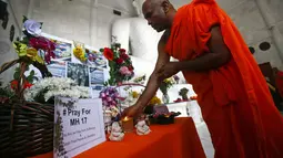 Di sebuah kuil Budha di Kuala Lumpur, seorang biksu memanjatkan doa buat para korban jatuhnya pesawat Malaysia Airlines MH-17, (20/7/2014). (REUTERS/Samsul Said)