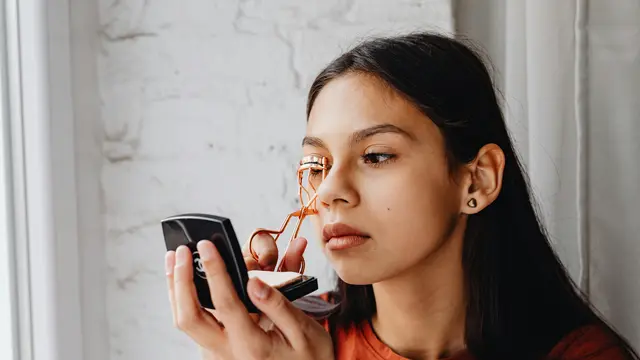 Perempuan dengan penjepit bulu mata