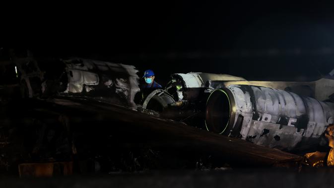Petugas memeriksa puing-puing pesawat yang mengalami kecelakaan di ujung landasan pacu 24 di Bandara Internasional Ninoy Aquino, Manila, Filipina (29/3/2020).  Pesawat Lionair ini berbeda dengan pesawat maskapai Lion Air di Indonesia.  (Xinhua/Rouelle Umali)