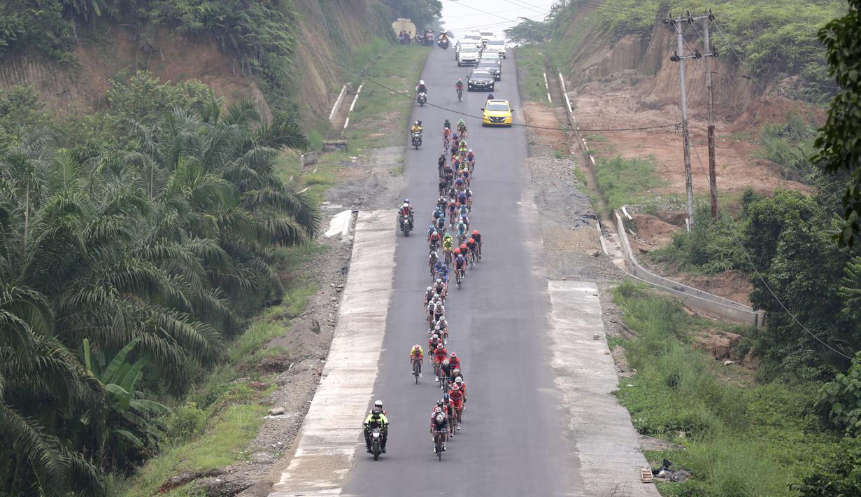 Para pebalap saat melewati perkebunan sawit di daerah Bawan, Kab. Agam di Etape 8 Tour de Singkarak 2015 dari Simpang Ampek, Pasaman Barat menuju Lawang Park, Kabupaten Agam, Sabtu (10/10/2015). (Bola.com/Arief Bagus)