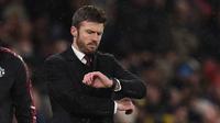 Hal itu disampaikan MU di laman resmi klub pada Rabu (14/1/2026) dini hari WIB. Tampak dalam foto, Michael Carrick saat masih menjadi pelatih sementara Manchester United melihat arlojinya selama pertandingan sepak bola Liga Premier Inggris melawan Arsenal di Old Trafford, Manchester, Inggris barat laut, pada 2 Desember 2021. (Oli SCARFF/AFP)