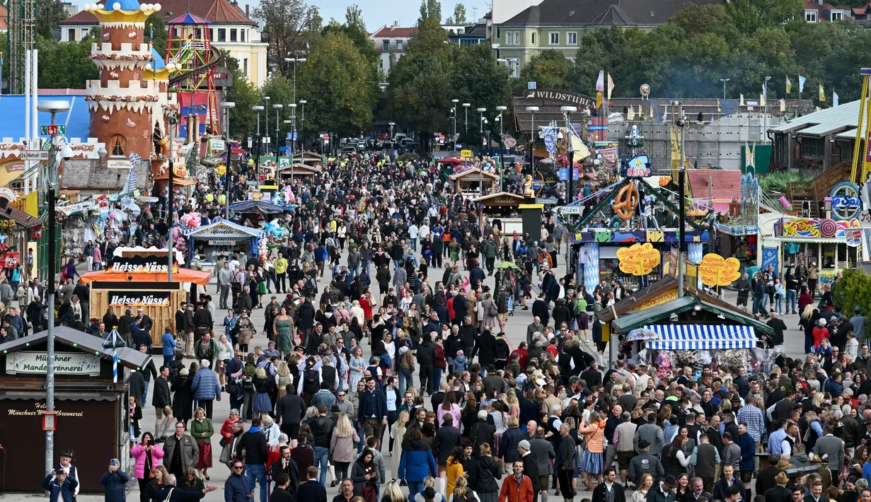 Pemandangan menunjukkan pengunjung berjalan di tempat pekan raya Theresienwiese selama festival bir Oktoberfest di Munich, Jerman selatan (20/9/2022). Festival Bir yang terkenal di dunia ini akan berlangsung hingga 3 Oktober 2022 tanpa batasan akses, setelah dua hari terakhir edisi tahun telah dibatalkan karena pandemi coronavirus. (AFP/Christof Stache)