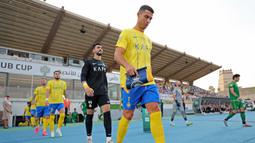 Pemain Al Nassr yang dipimpin oleh Cristiano Ronaldo berjalan memasuki lapangan saat laga semifinal Liga Champions Arab 2023 melawan Al Shorta di Prince Sultan bin Abdul Aziz Stadium, Abha, 9 Agustus 2023. Al Nassr sukses melaju ke babak final setelah menang dengan skor 1-0. (AFP/Abdullah Mahdi)