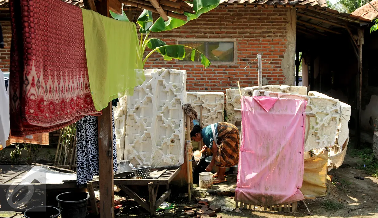Ramah yang merupakan nenek dari Indrawan sedang menyiapkan air untuk mandi cucunya di Kampung Katimaha, Bekasi, Jawa Barat, (11/7). Kelainan tersebut diketahui saat Indrawan diperiksa kondisi kesehatannya di Puskesmas. (Liputan6.com/Gempur M Surya)
