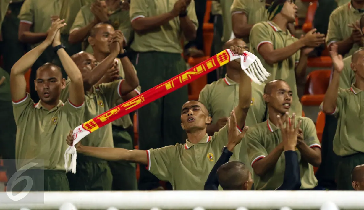 Salah satu suporter PS TNI membentangkan syal saat menyaksikan laga timnya melawan Persib di lanjutan Liga 1 di Stadion Pakansari, Kab Bogor, Sabtu (22/4). Laga PS TNI melawan Persib berakhir imbang 2-2. (Liputan6.com/Helmi Fithriansyah)
