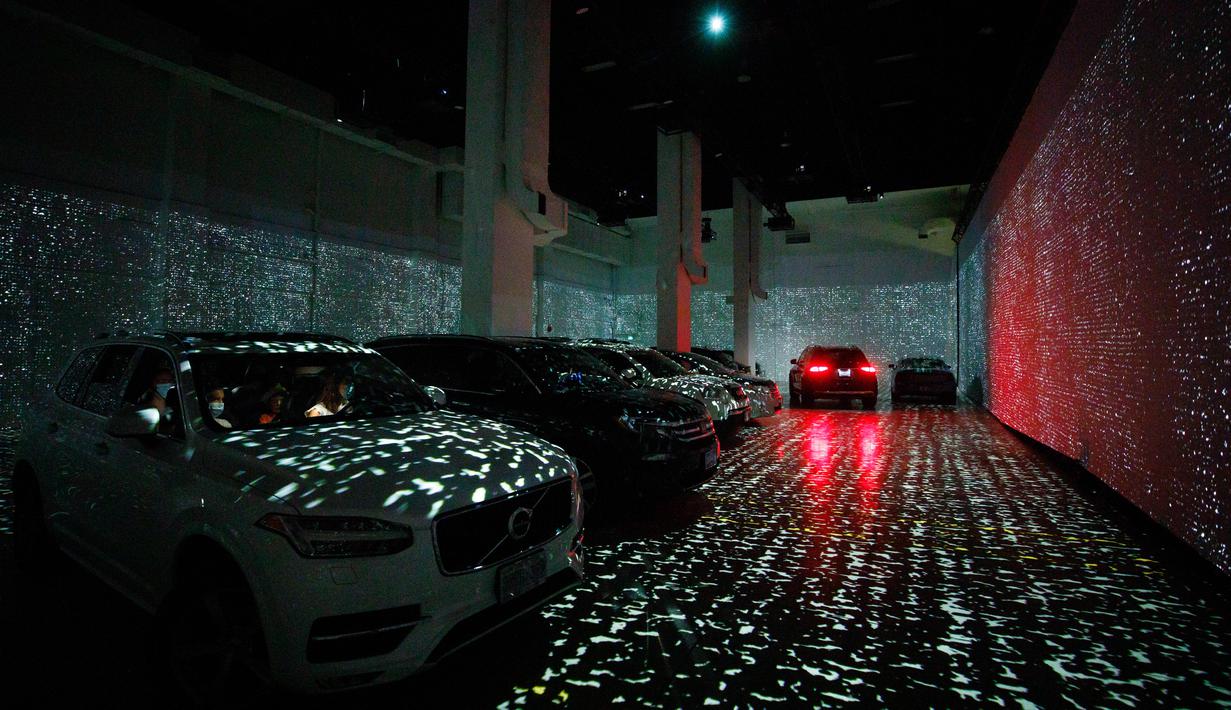 Orang-orang duduk di mobil mereka menikmati pameran seni Vincent Van Gogh di Toronto, Ontario, Kanada pada 3 Juli 2020. Pameran seni di masa pandemi Covid-19 mendatangkan ide kreatif para penyelenggara kegiatan dengan memamerkan hasil karya seni lewat konsep drive-in. (Cole BURSTON/AFP)