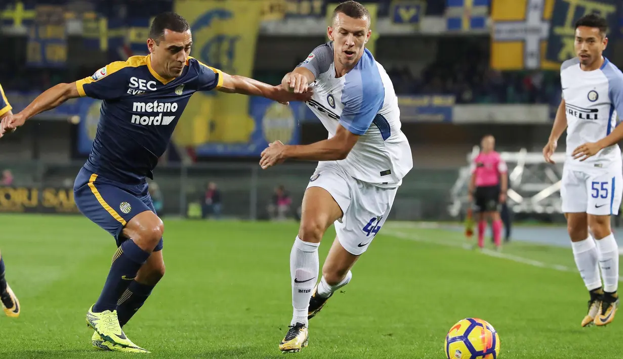 Pemain Inter Milan, Ivan Perisic berebut bola dengan pemain Hellas Verona, Orestes Romulo dalam lanjutan pertandingan Liga Serie A Italia di Marc'Antonio Bentegodi, Selasa (31/10). Inter menang 2-1 atas tuan rumah Verona. (Filippo Venezia/ANSA via AP)