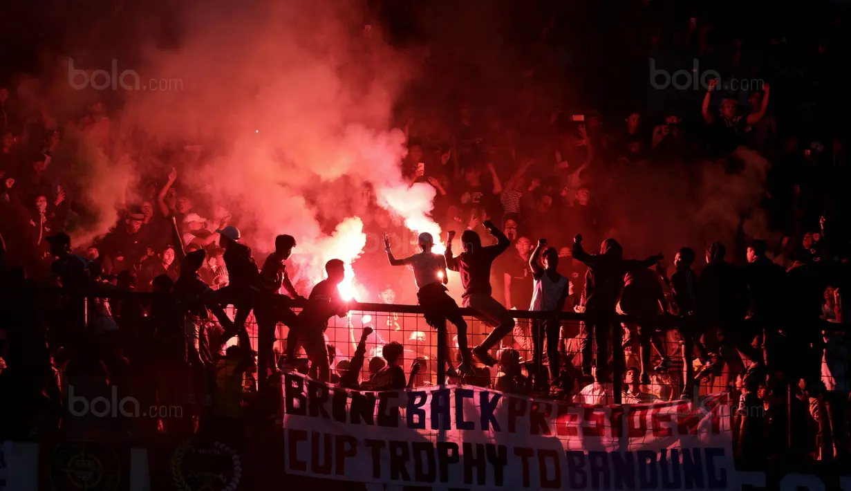 Suporter Persib menyalakan flare usai pertandingan melawan PSM pada laga Piala Presiden di Stadion GBLA, Bandung, Jumat (26/1/2018). Persib takluk 0-1 dari PSM. (Bola.com/M Iqbal Ichsan)
