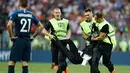 Petugas mengamankan seorang wanita yang menyusup masuk ke lapangan pada laga final Piala Dunia 2018 antara Prancis dan Kroasia di Luzhniki Stadium, Minggu (15/7). Grup band anti-Kremlin mengaku sebagai penyusup laga final itu. (AP/Matthias Schrader)