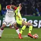 Duel gelandang Lyon, Martin Terrier dan Sergi Roberto pada leg 1, babak 16 besar Liga Champions yang berlangsung di stadion Parc Olympique Lyonnais, Lyon, Rabu (20/2). Barcelona bermain imbang 0-0 kontra Lyon. (AFP/Franck Fife)