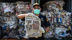 Petugas Bea Cukai Tanjung Perak menunjukkan koran dari kontainer berisi sampah asal Australia di Pelabuhan Tanjung Perak, Surabaya, Jawa Timur, Selasa (9/7/2019). Kantor Bea Cukai Tanjung Perak menindak barang impor berupa delapan kontainer sampah kertas asal Australia. (JUNI KRISWANTO/AFP)