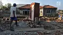 Darmin berjalan di atas reruntuhan bangunan rumahnya yang roboh akibat abrasi. Pria 75 tahun itu ialah satu dari puluhan warga di Kampung Beting yang rumahnya rusak hingga roboh akibat tak kuat menahan gelombang air laut yang kerap terjadi. (merdeka.com/Iqbal S Nugroho)