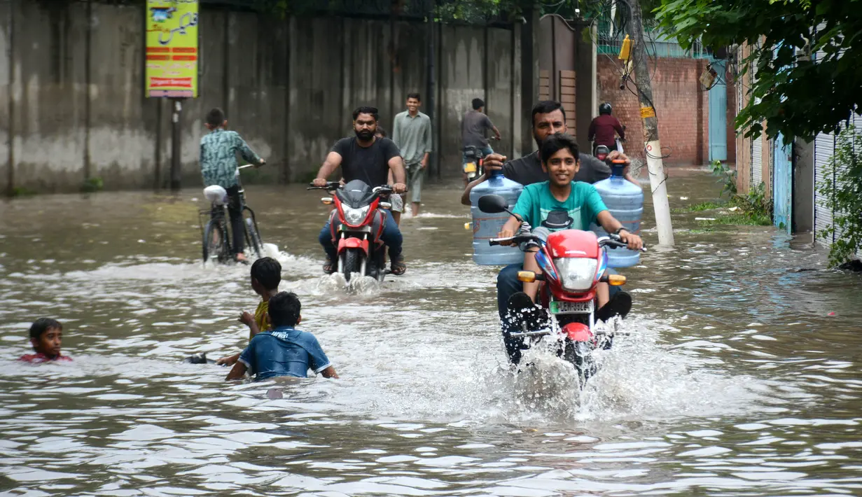 Belasan Tewas Akibat Hujan Lebat di Punjab: Warga mengendarai motor di jalanan yang terendam banjir setelah hujan lebat di Lahore, Punjab, Pakistan, 20 Agustus 2020. Sebanyak 18 orang tewas dan banyak lainnya terluka akibat hujan lebat di Punjab. (Xinhua/Sajjad)