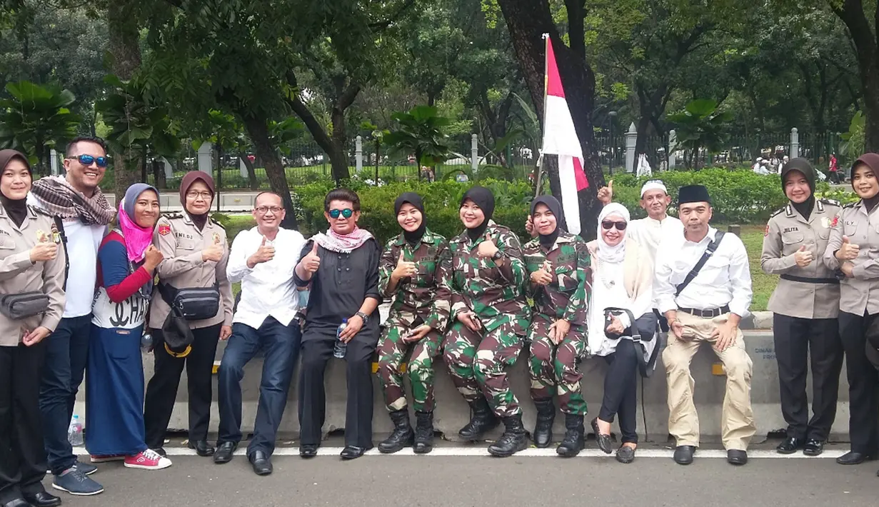 Sejumlah pengunjuk rasa berpose dengan parjurit TNI berhijab dan Polwan Berhijab saat Aksi Damai 4 November di Jakarta, Jumat (4/11). Aksi ini menuntuk Gubernur Ahok untuk diadili karena diduga menistakan agama. (Twitter.com/@ekagumilars)