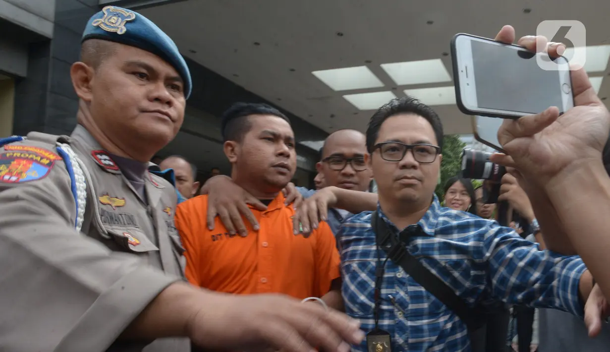 Polisi mengawal tersangka kasus penyiramanan air keras terhadap penyidik senior KPK Novel Baswedan di Polda Metro Jaya, Jakarta, Sabtu (28/12/2019). Tersangka berinisial RM dan RB dipindahkan dari Polda Metro Jaya ke Bareskrim Mabes Polri untuk penyidikan lebih lanjut. (merdeka.com/Imam Buhori)