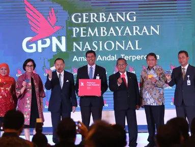 Ketua Asosiasi Sistem Pembayaran Indonesia (ASPI) Anggoro Eko Cahyo (tengah) bersama sejumlah menteri Kabinet Kerja, menunjukkan kartu Gerbang Pembayaran Nasional (GPN) saat peresmian di Gedung BI, Jakarta, Senin (4/12). (Liputan6.com/Angga Yuniar)