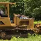 Vin Diesel sedang belajar mengendarai traktor Caterpillar di sebuah lahan peternakan di Eropa.