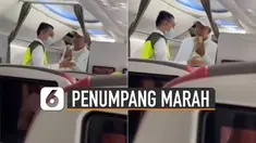 Seorang petugas dengan rompi jadi sasaran amarah penumpang berjaket putih.