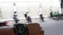 Petugas memperlihatkan jam saat  sosialisasi aturan jam malam di kawasan Margonda, Depok, Senin (31/8/2020). Pemkot Depok, Jawa Barat, mulai menerapkan aturan jam malam yang membatasi kegiatan masyarakat di luar rumah untuk menekan risiko penularan Covid-19. (Liputan6.com/Herman Zakharia)